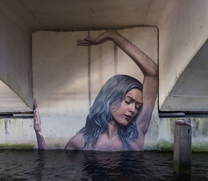 Este artista pinta asombrosos murales a nivel del mar sobre una tabla de surf 