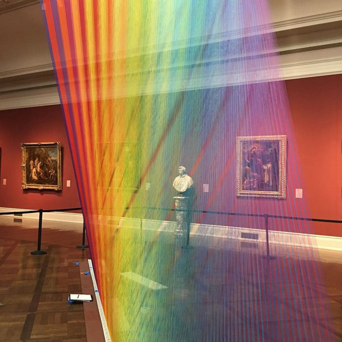 Este arco iris artificial atrapado en una galería de arte está hecho con miles de hilos de colores 