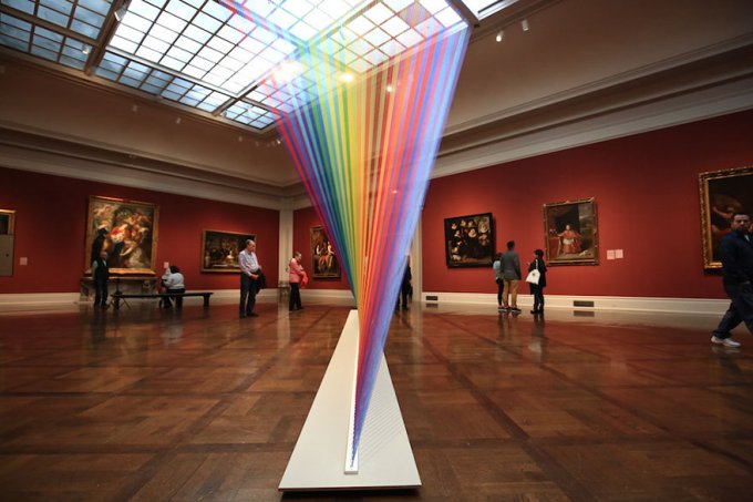 Este arco iris artificial atrapado en una galería de arte está hecho con miles de hilos de colores 